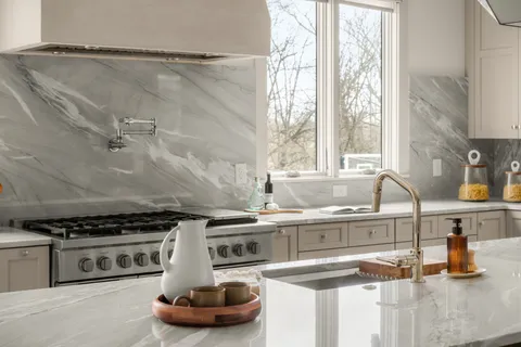 a bathroom with a granite countertop sink a toilet a mirror and bathtub