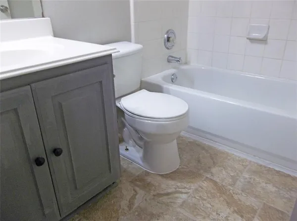 a white toilet sitting next to a bath tub