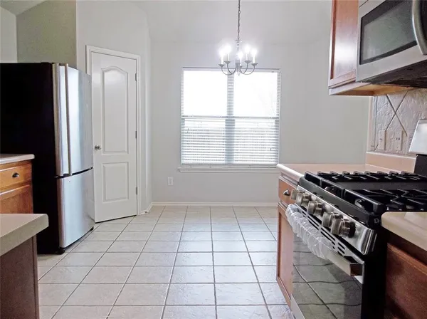 a kitchen with a stove a refrigerator and a cabinets