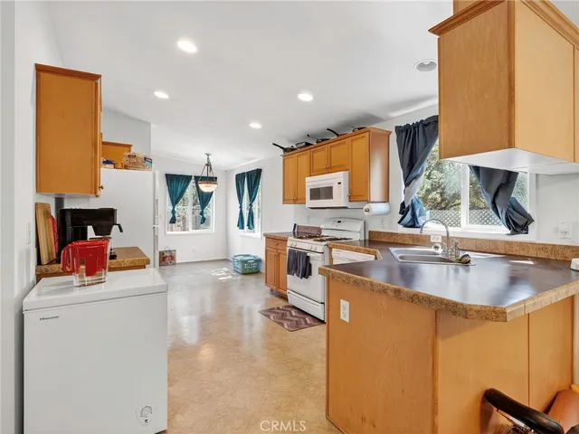 a kitchen with stainless steel appliances granite countertop a sink a stove and a refrigerator