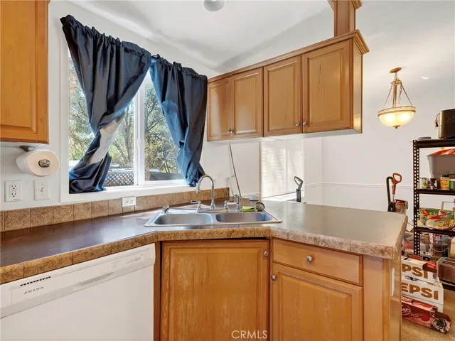 a kitchen with stainless steel appliances granite countertop a sink a refrigerator and a granite counter tops with a window