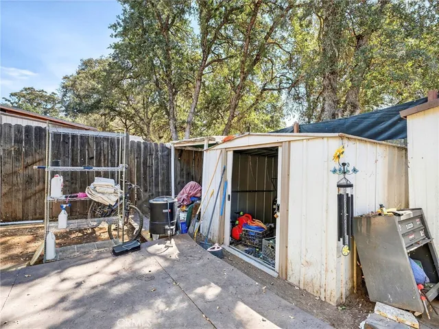 a view of a patio with table and chairs and a barbeque