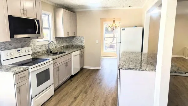 a kitchen with stainless steel appliances a refrigerator sink and microwave