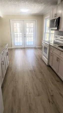 a kitchen with stainless steel appliances granite countertop a stove a sink dishwasher and a microwave with wooden floor