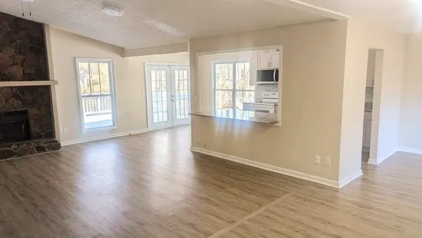 an empty room with wooden floor and fireplace