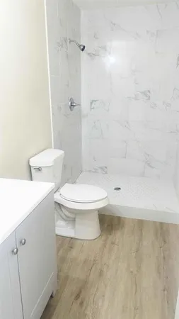a white toilet sitting next to a bath tub shower