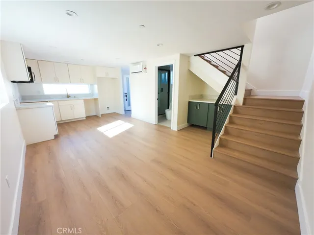 a view of a kitchen with wooden floor and electronic appliances