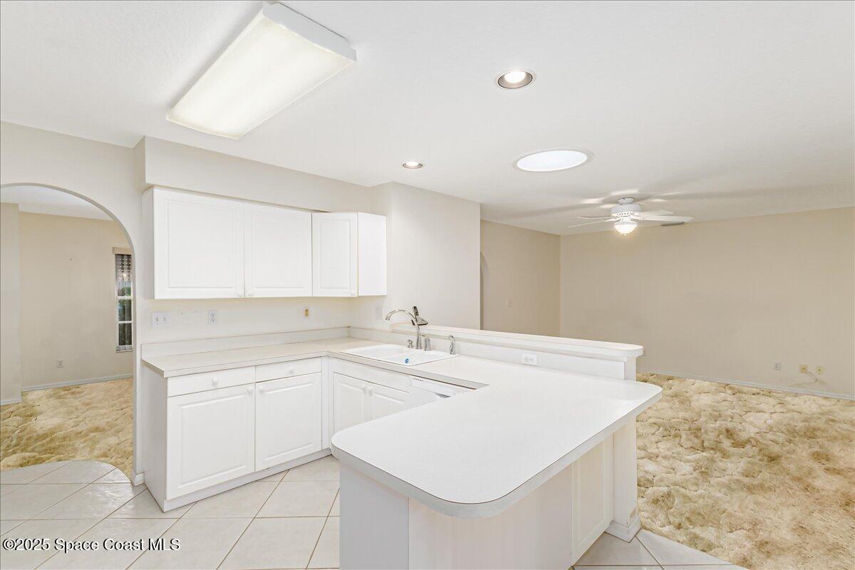 948 Pelican Lane Rockledge, FL 32955 - Photo 12 of 38 a kitchen with granite countertop a sink stainless steel appliances and white cabinets