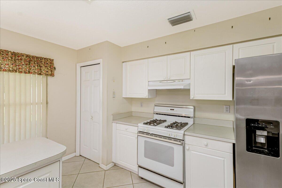 948 Pelican Lane Rockledge, FL 32955 - Photo 14 of 38 a kitchen with white cabinets and white appliances