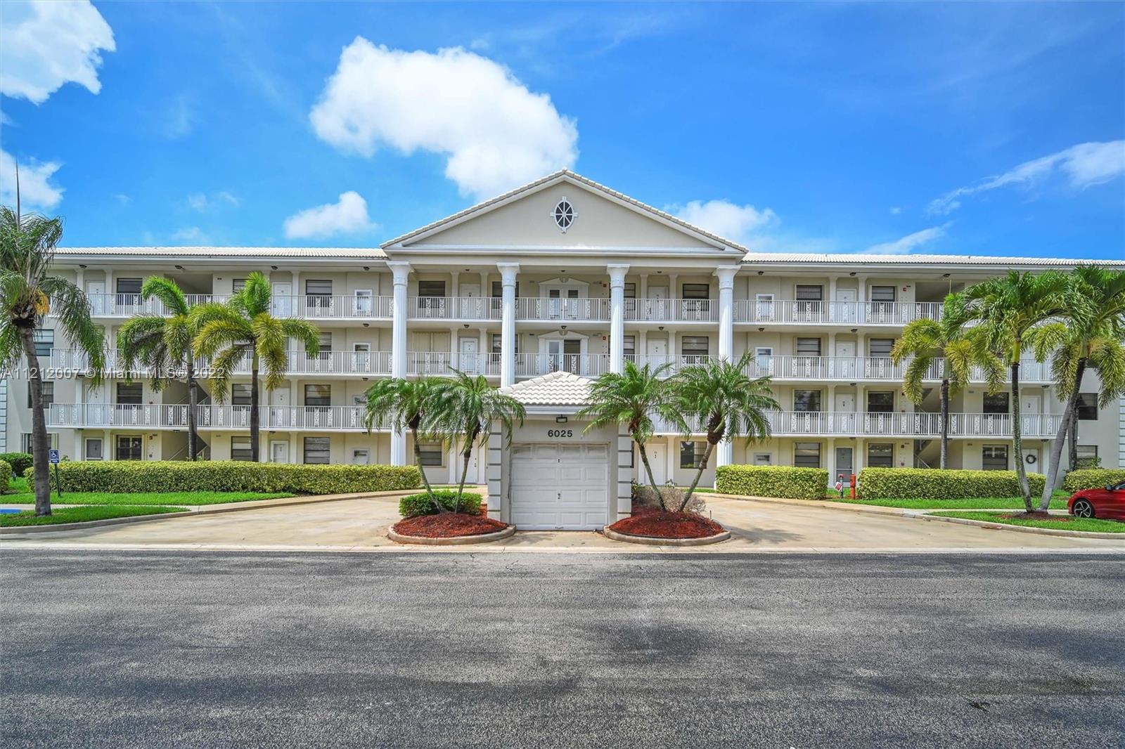 6025 Balboa Circle, Unit 202 Boca Raton, FL 33433 - Photo 2 of 28 a front view of a building with a garden and plants