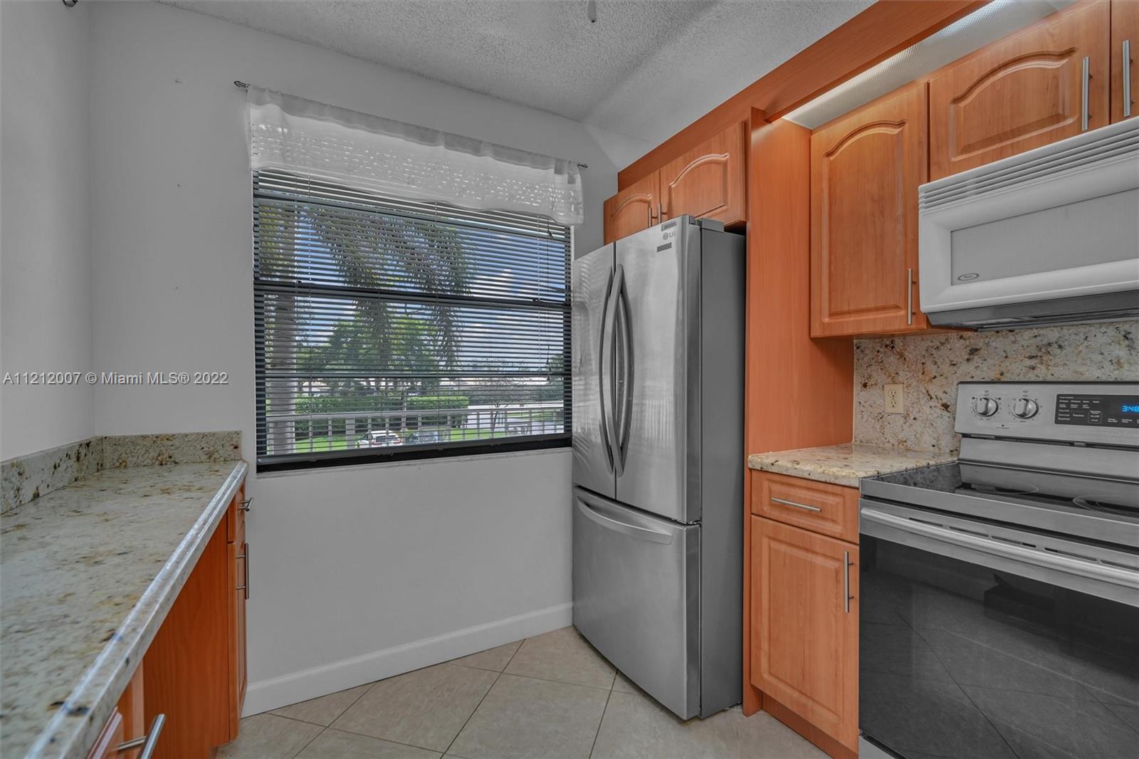 6025 Balboa Circle, Unit 202 Boca Raton, FL 33433 - Photo 8 of 28 a kitchen with granite countertop a refrigerator and a stove