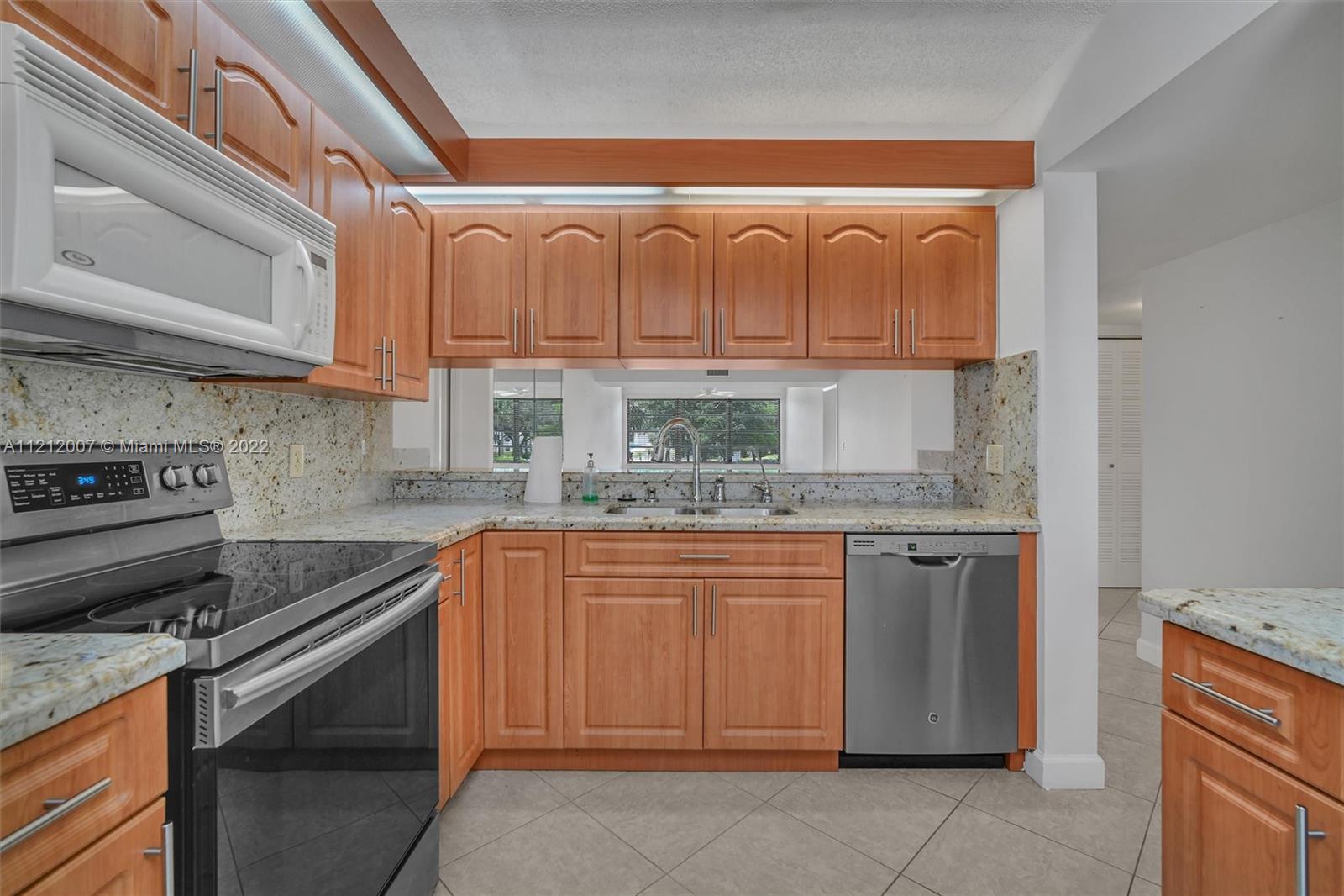 6025 Balboa Circle, Unit 202 Boca Raton, FL 33433 - Photo 9 of 28 a kitchen with stainless steel appliances granite countertop a stove and a sink