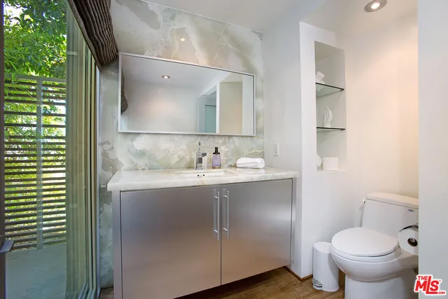 a bathroom with a granite countertop sink toilet and shower