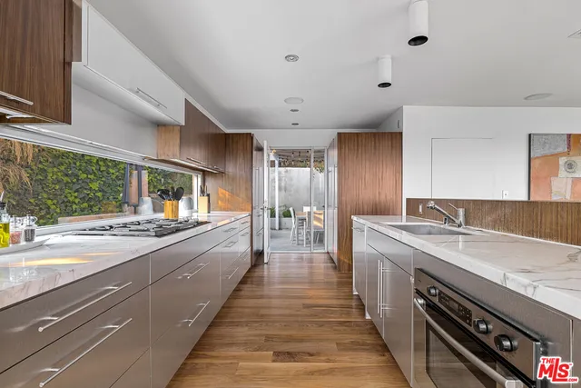 a large kitchen with stainless steel appliances granite countertop a lot of counter space and a sink
