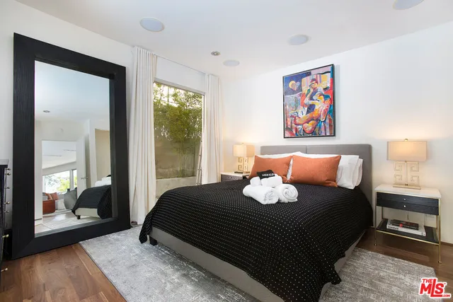 a bedroom with a bed and a painting on the wall