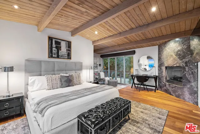 a bedroom with a bed a table and a potted plant