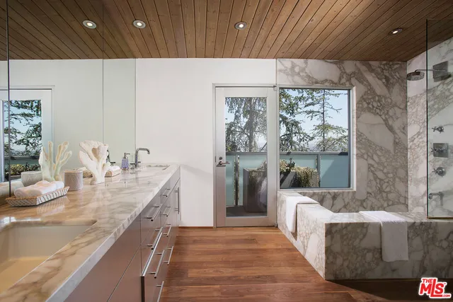 a large room with kitchen island granite countertop a dining table chairs and a large window