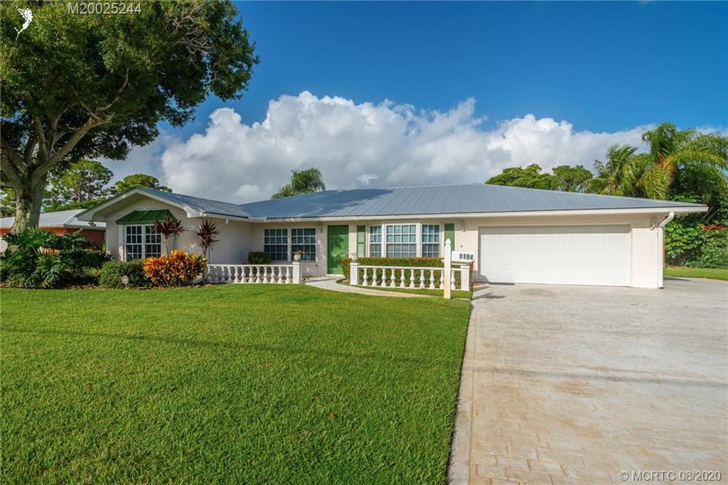 1194 Northwest Spruce Ridge Drive Stuart, FL 34994 - Photo 1 of 34 front view of a house with a yard