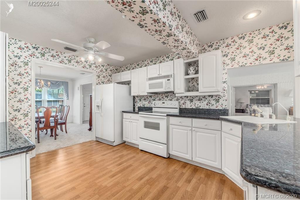 1194 Northwest Spruce Ridge Drive Stuart, FL 34994 - Photo 16 of 34 a large white kitchen with granite countertop a large counter top and sink