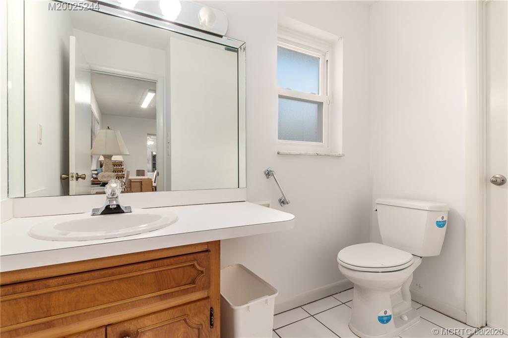 1194 Northwest Spruce Ridge Drive Stuart, FL 34994 - Photo 19 of 34 a bathroom with a sink a toilet and mirror