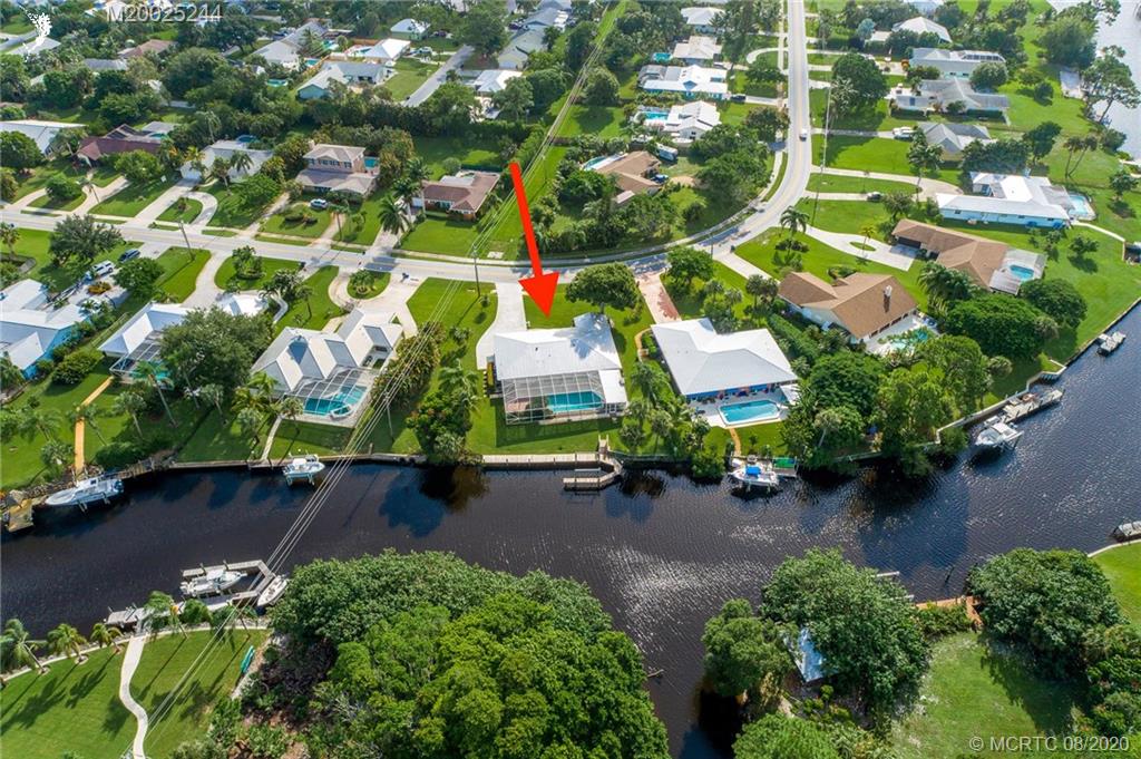 1194 Northwest Spruce Ridge Drive Stuart, FL 34994 - Photo 3 of 34 an aerial view of a house with a yard and lake view