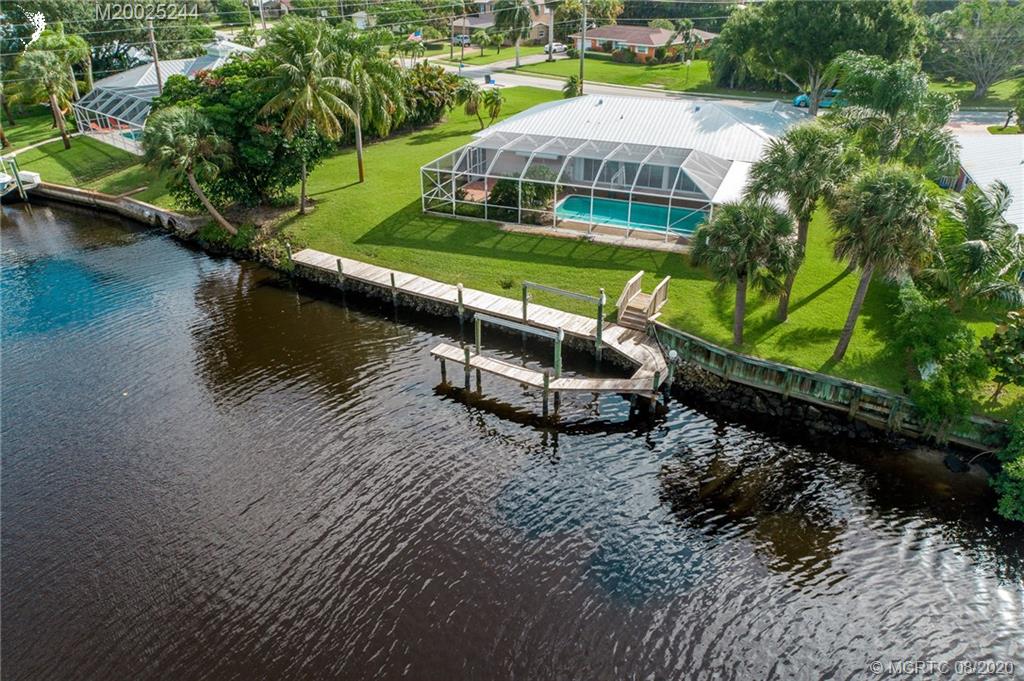 1194 Northwest Spruce Ridge Drive Stuart, FL 34994 - Photo 6 of 34 an aerial view of a house with swimming pool and lake view