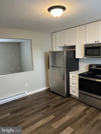 a view of a kitchen with wooden floor and window