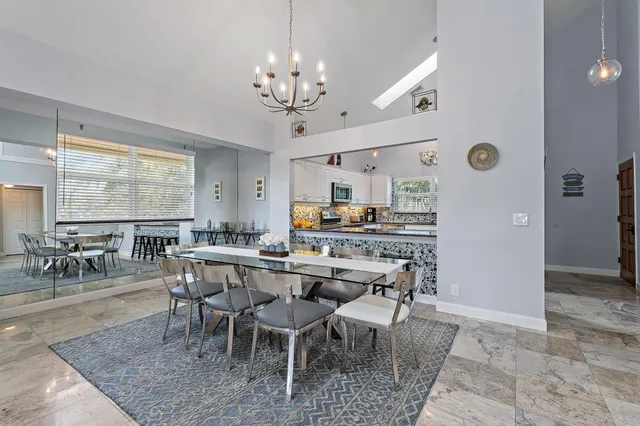 a living room with furniture kitchen view and a large window