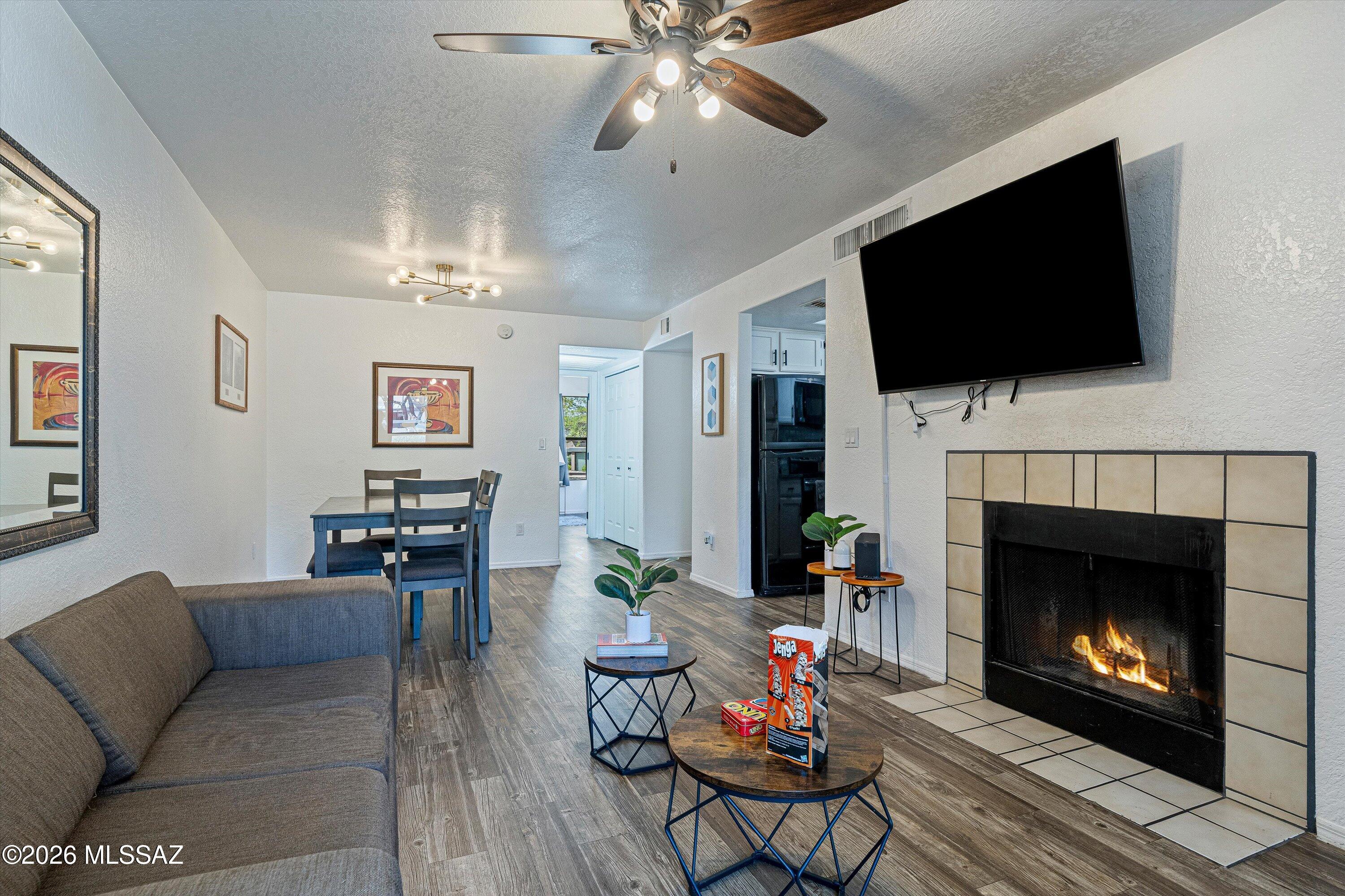 5800 North Kolb Road, Unit 1102 Tucson, AZ 85750 - Photo 5 of 36 a living room with furniture a flat screen tv and a fireplace