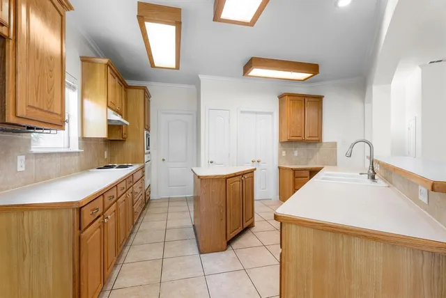 a kitchen with stainless steel appliances a sink stove and cabinets