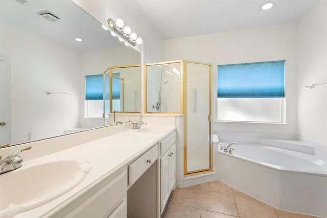 a spacious bathroom with a bathtub sink and mirror