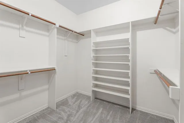a view of walk in closet with empty racks