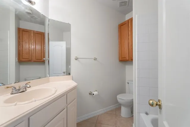 a bathroom with a granite countertop sink a toilet and a mirror
