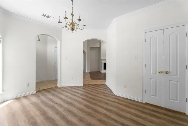 a view of a chandelier in big room with wooden floor