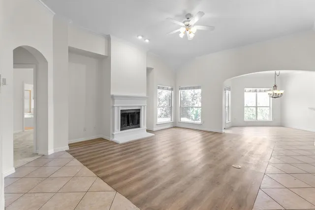 a view of an empty room with a fireplace and a window