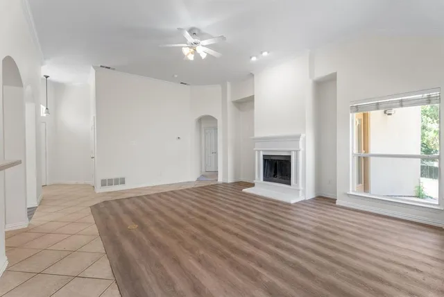 a view of an empty room with a window and fireplace