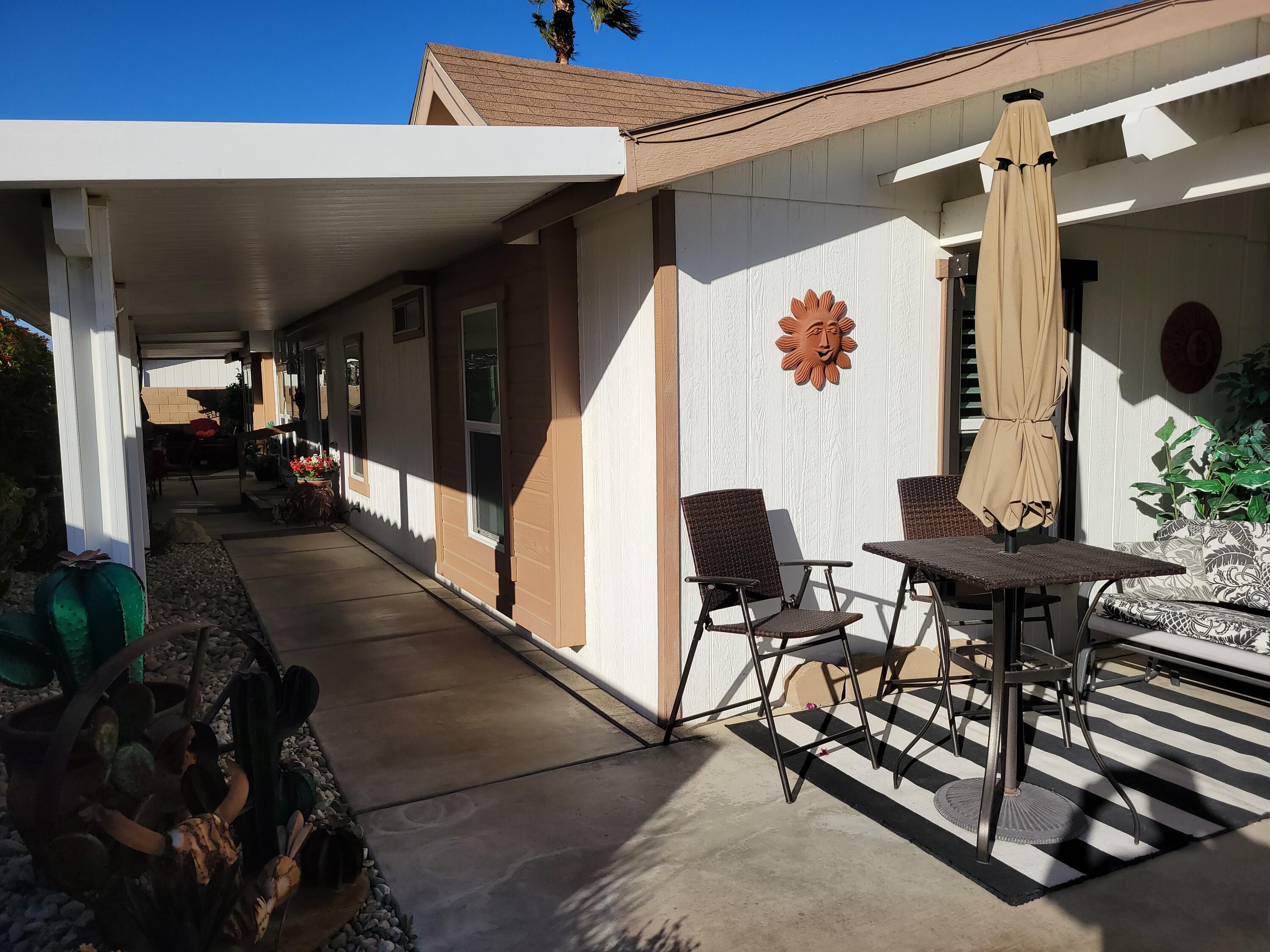 81641 Ave 48, Unit 56 Indio, CA 92201 - Photo 18 of 28 a view of balcony with chairs and potted plants