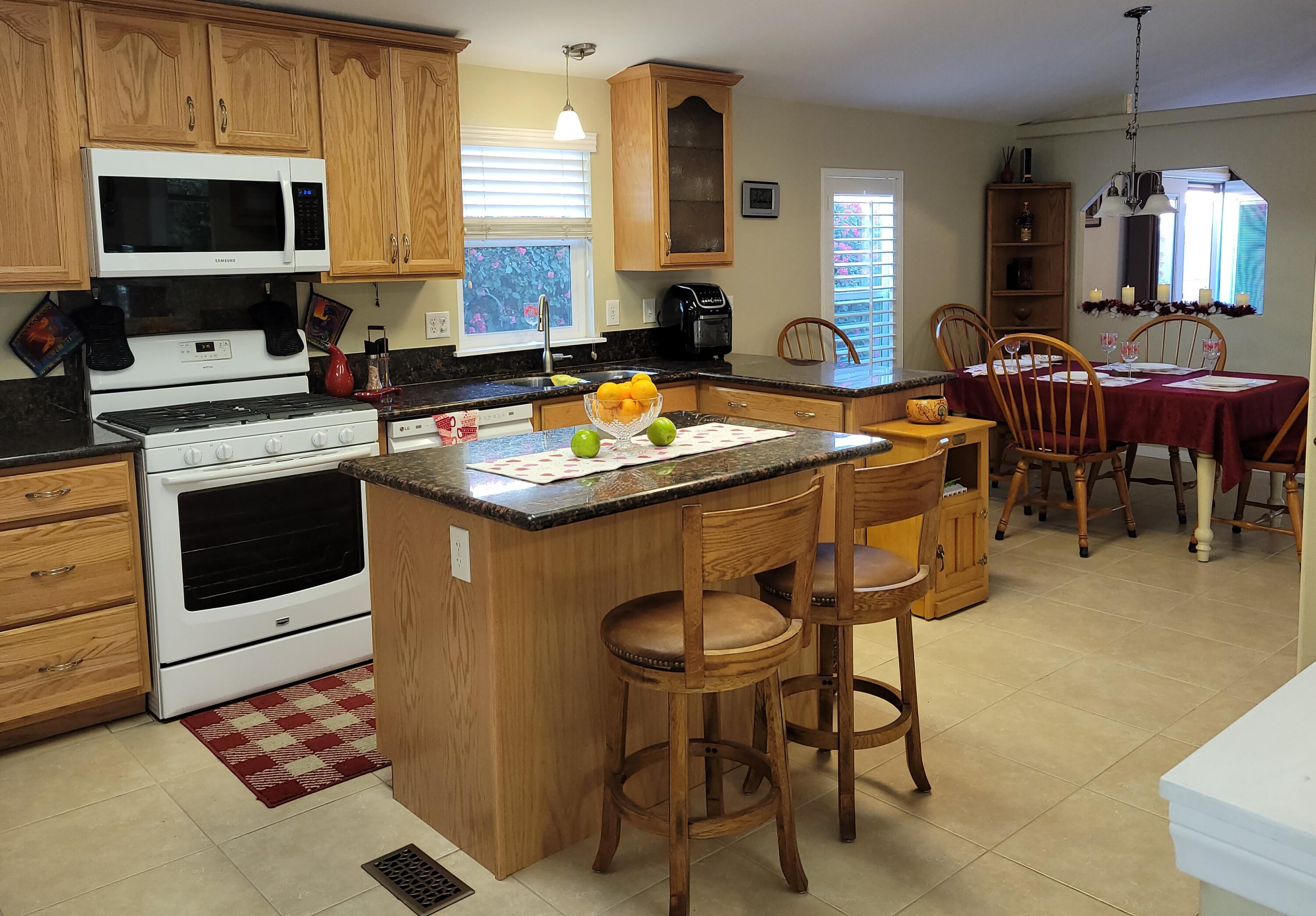 81641 Ave 48, Unit 56 Indio, CA 92201 - Photo 4 of 28 a kitchen with stainless steel appliances granite countertop wooden cabinets a stove a sink and a microwave