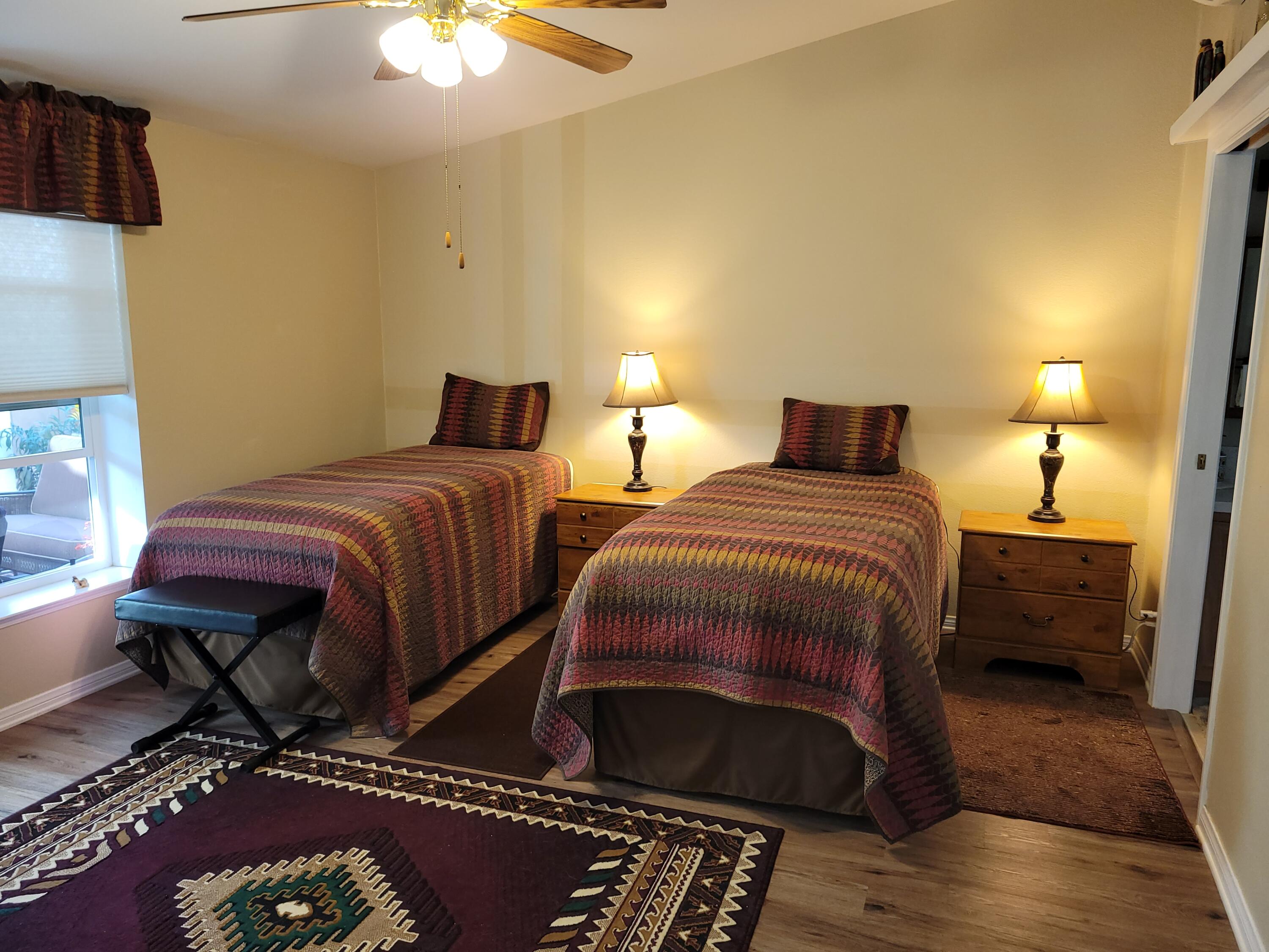 81641 Ave 48, Unit 56 Indio, CA 92201 - Photo 10 of 28 a bedroom with two beds and a chandelier