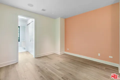 an empty room with wooden floor & windows