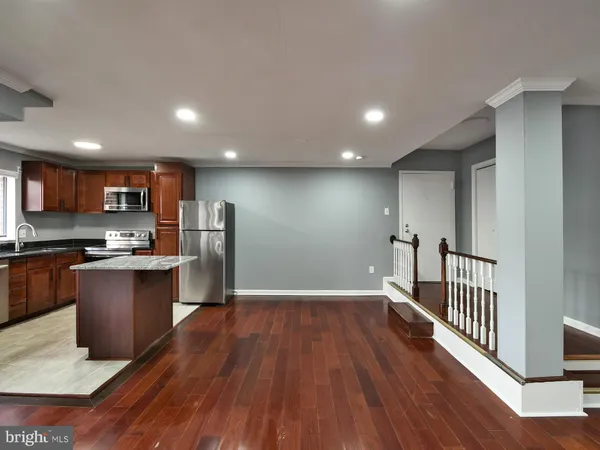 a view of an empty room with wooden floor and entryway