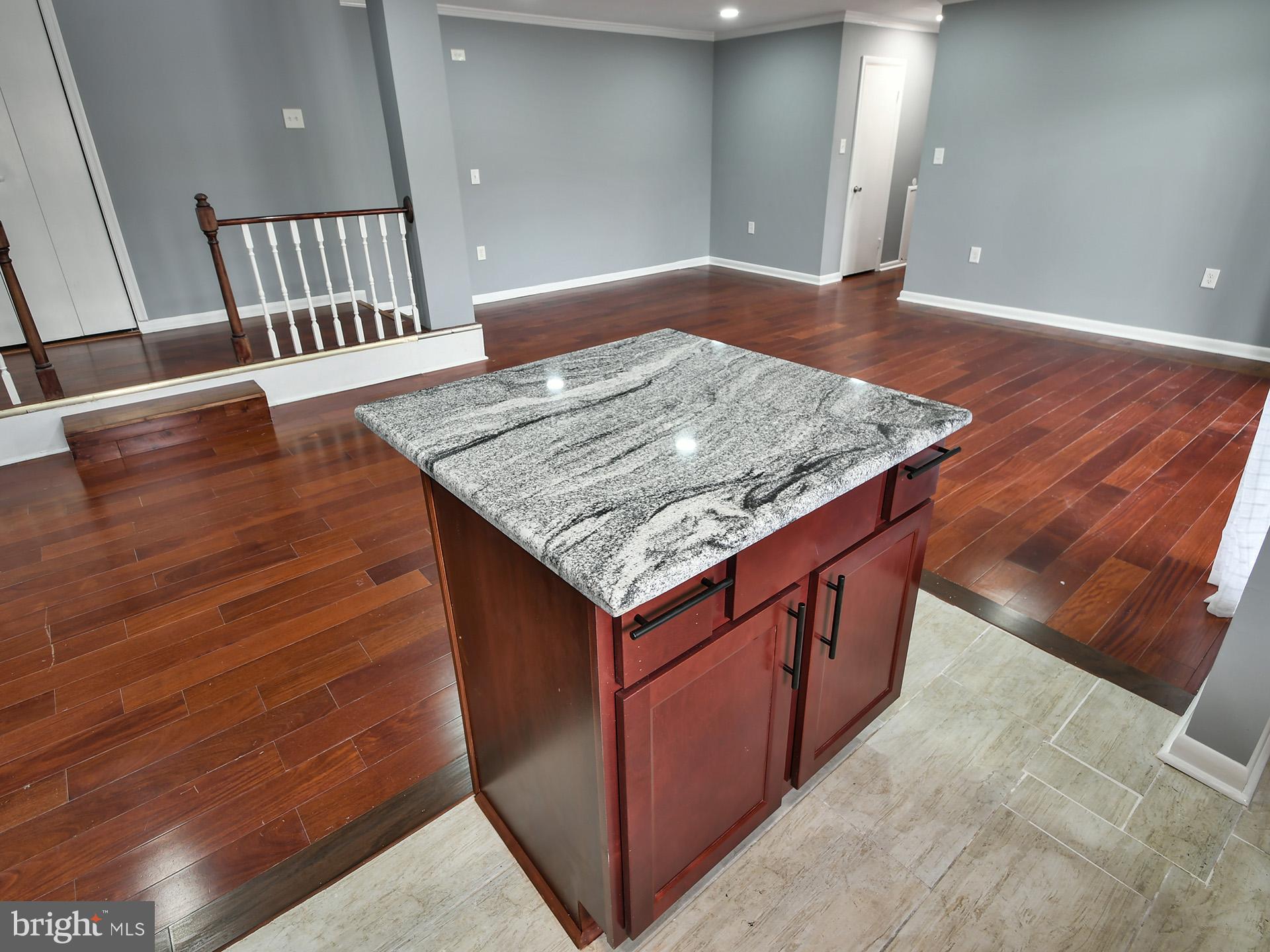 15712 Dorset Road, Unit 104 Laurel, MD 20707 - Photo 20 of 49 a view of kitchen island with granite countertop wooden floor and a sink