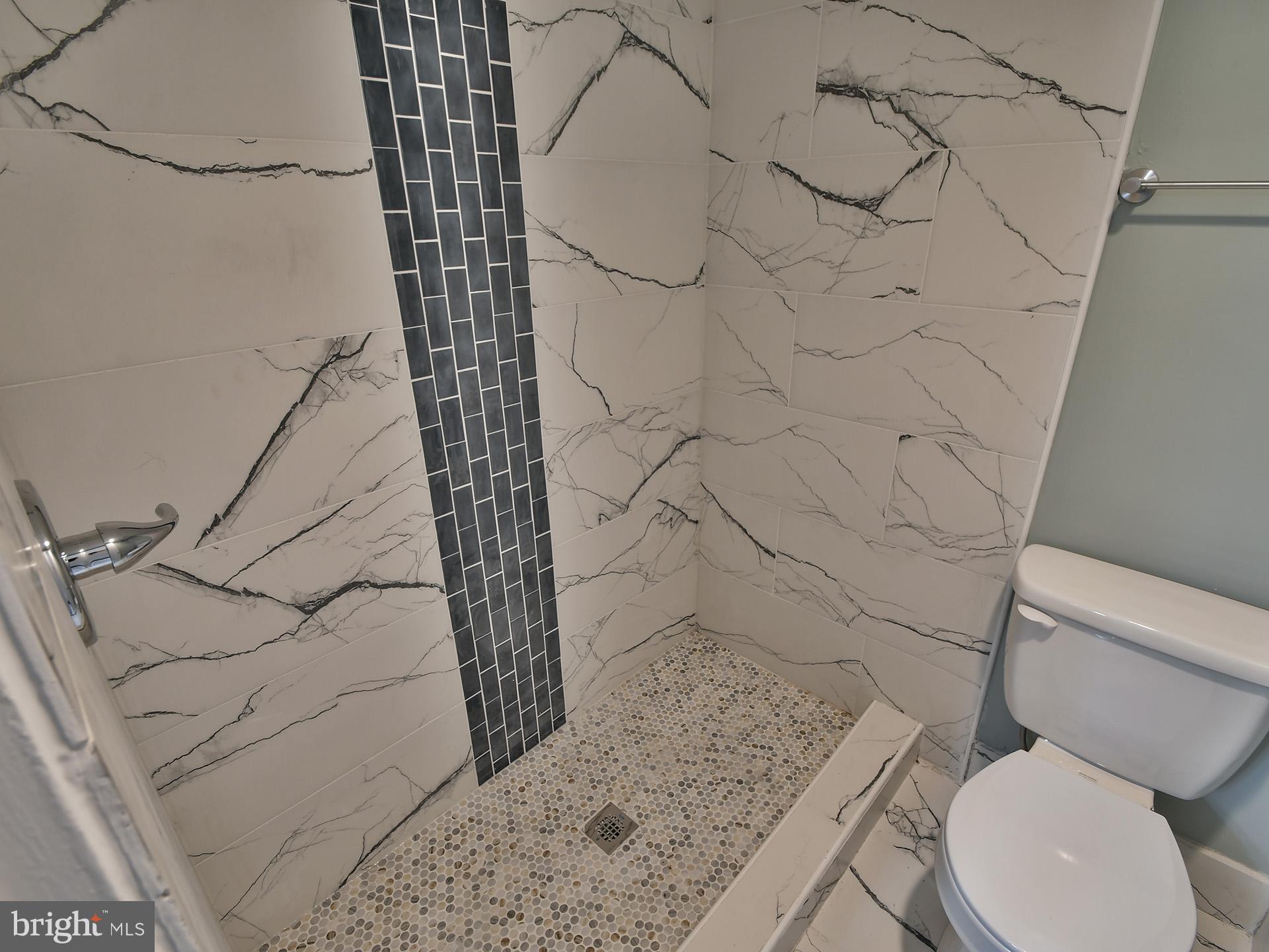 15712 Dorset Road, Unit 104 Laurel, MD 20707 - Photo 29 of 49 a white toilet sitting next to a shower curtain