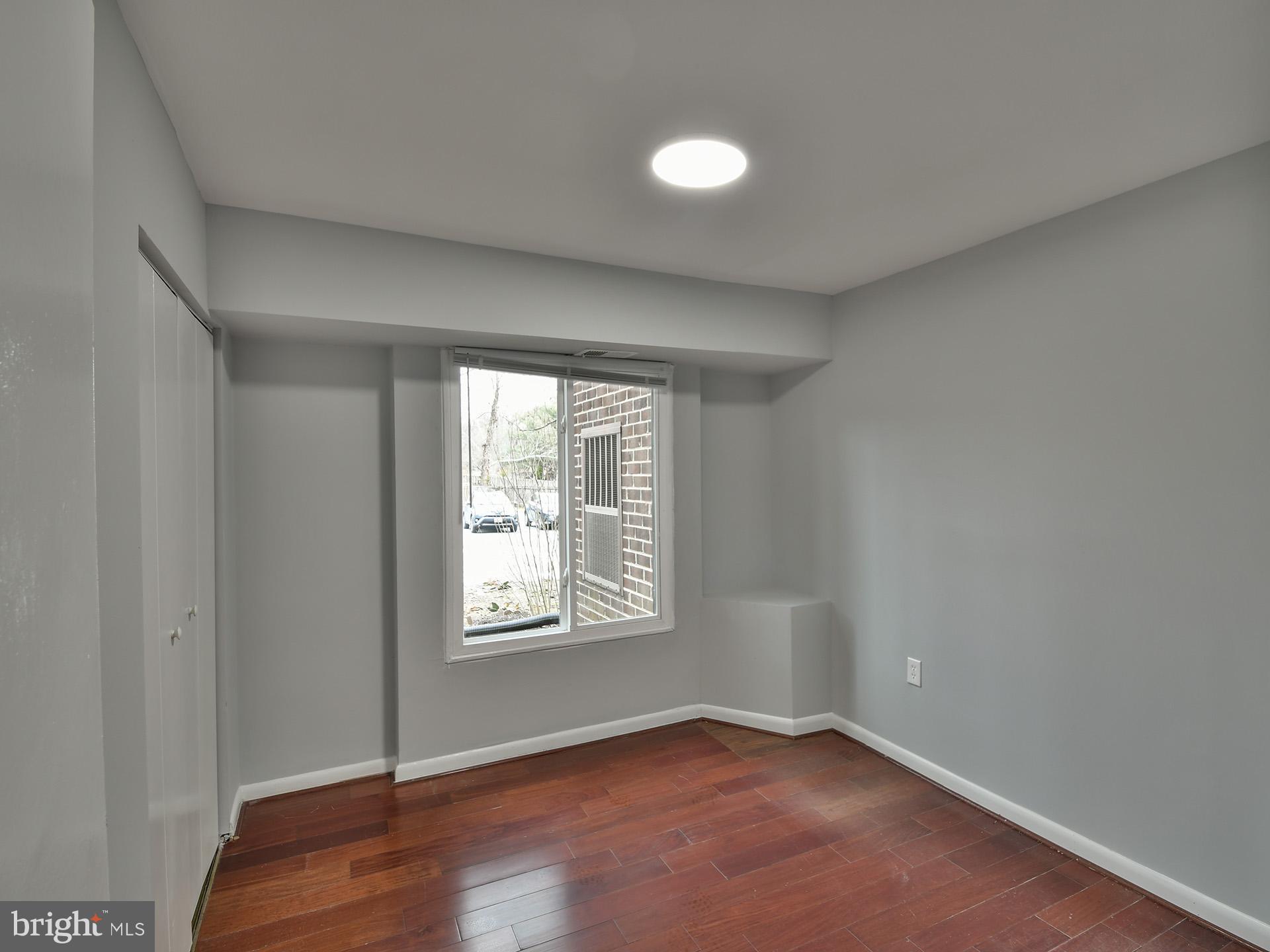 15712 Dorset Road, Unit 104 Laurel, MD 20707 - Photo 35 of 49 an empty room with wooden floor and windows