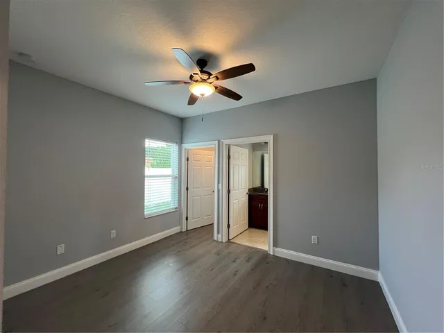 an empty room with closet and windows