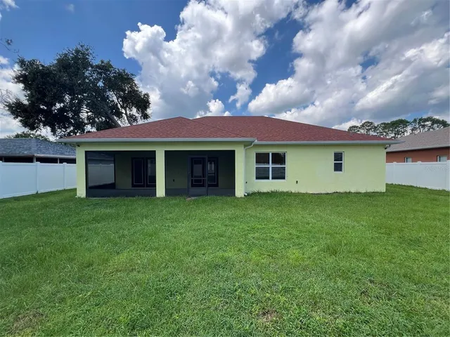 a view of a yard in front of a house with a large tree