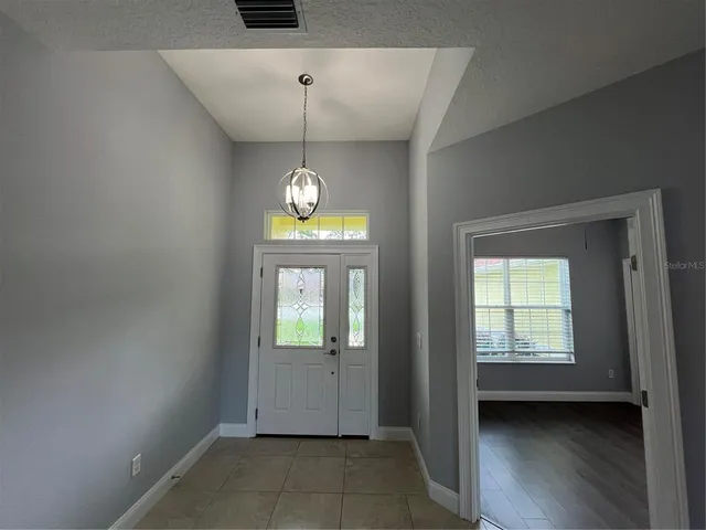 an empty room with windows and chandelier