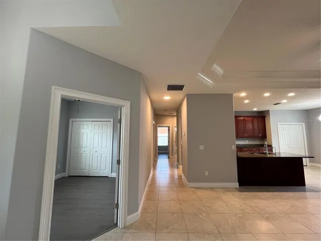 a view of a hallway with kitchen and granite counter top