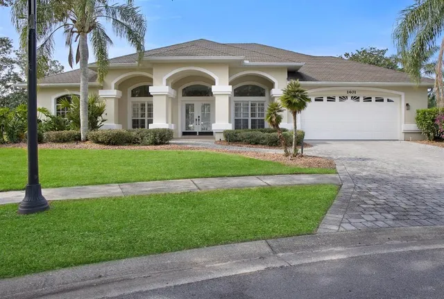 a front view of a house with a garden and plants