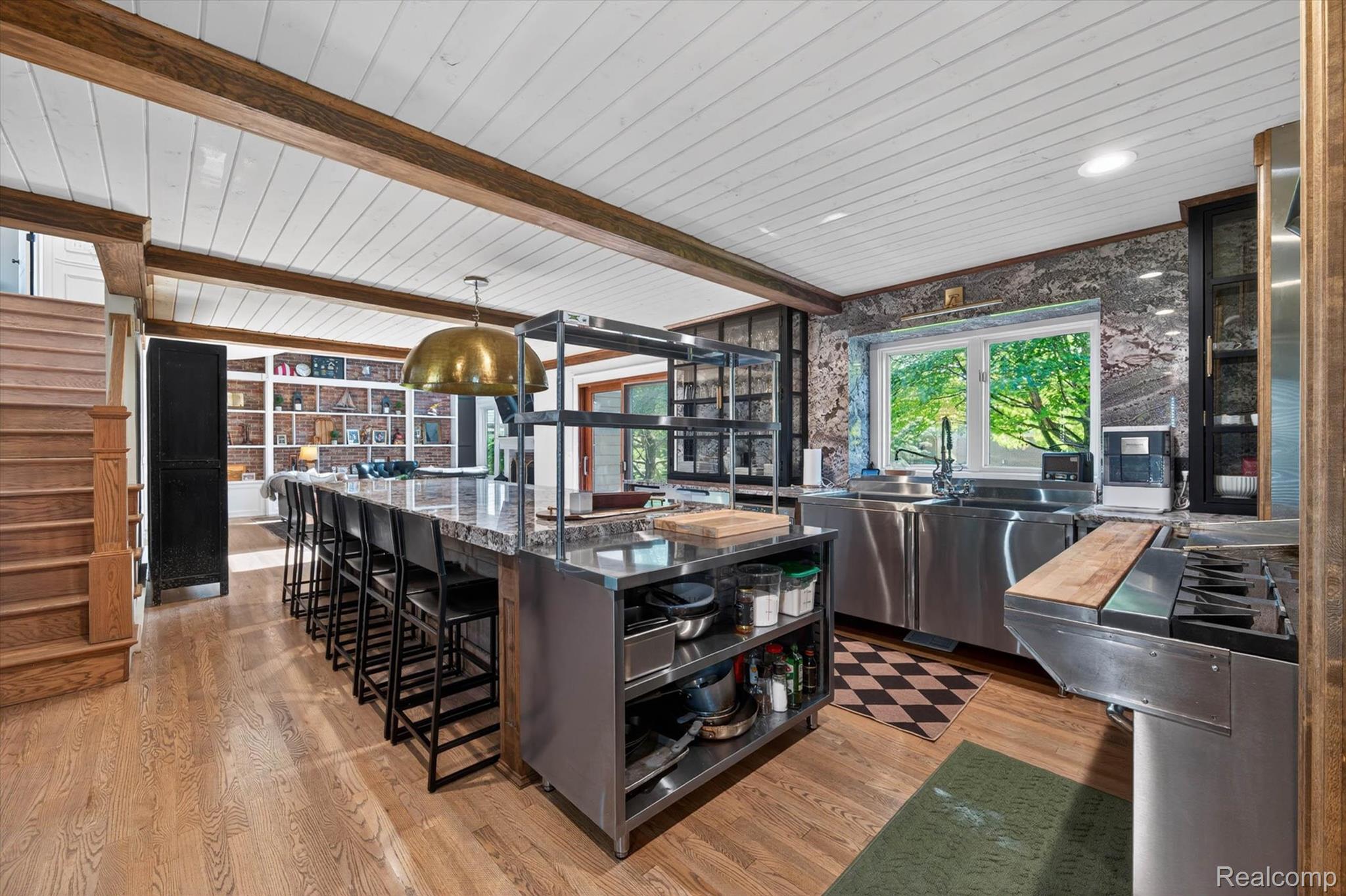 371 Lone Pine Circle Rochester, MI 48307 - Photo 17 of 59 Open-concept kitchen featuring an oversized island with seating, stainless steel appliances, and a window overlooking exterior greenery